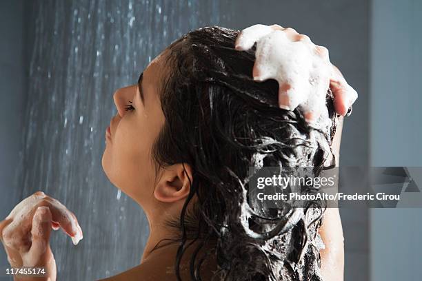 woman washing her hair in shower - women haircare stock-fotos und bilder