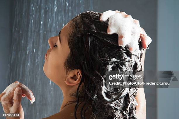 woman washing her hair in shower - cheveux photos et images de collection