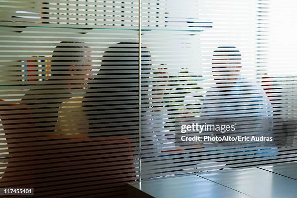 meeting in office viewed through glass wall - private view stock-fotos und bilder