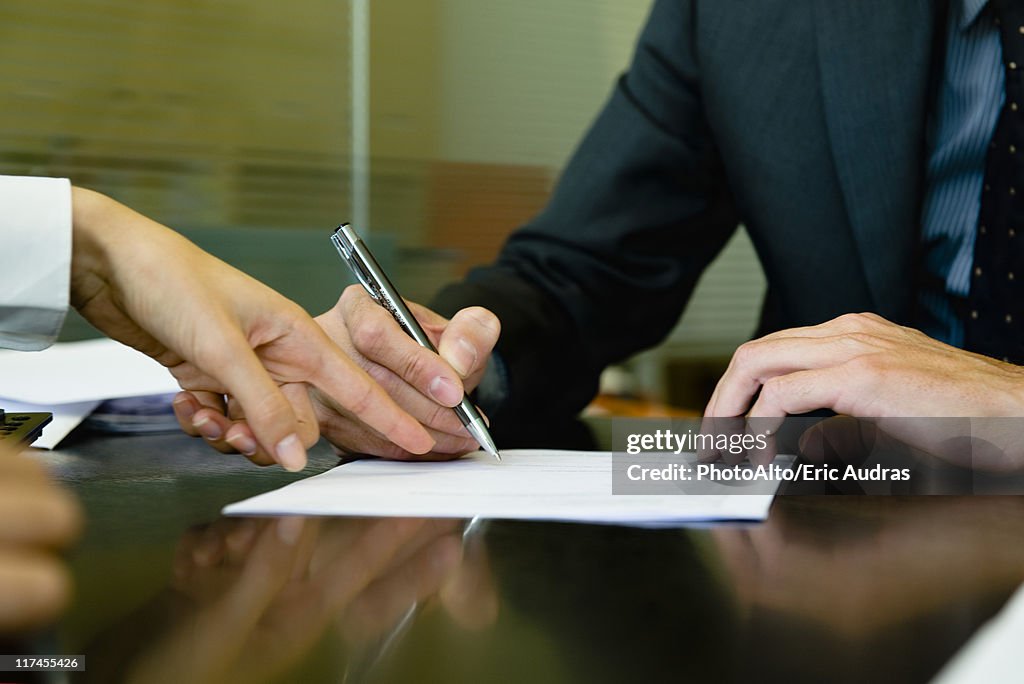 Executive signing paperwork