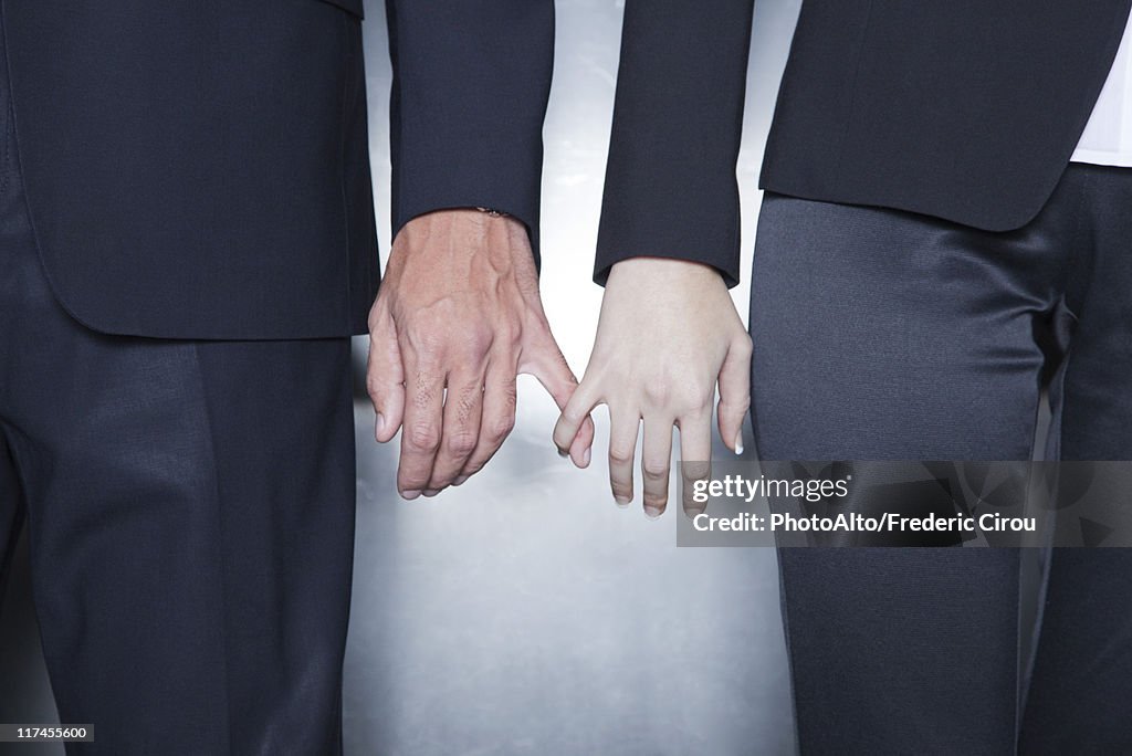 Professionals holding hands, cropped