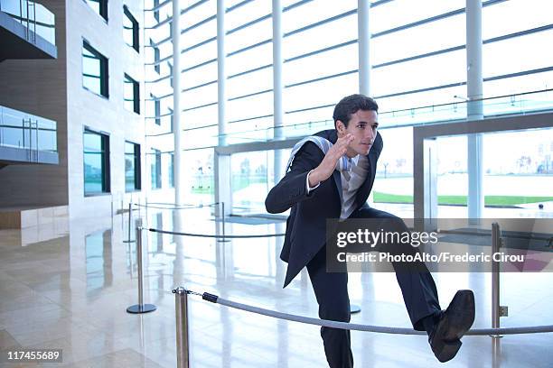 businessman jumping over rope in lobby - roped off stock pictures, royalty-free photos & images