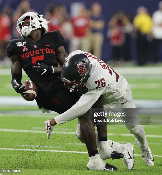 Bryce Beekman of the Washington State Cougars forces Marquez Stevenson of the Houston Cougars to fumble the ball in the fourth quarter during the...