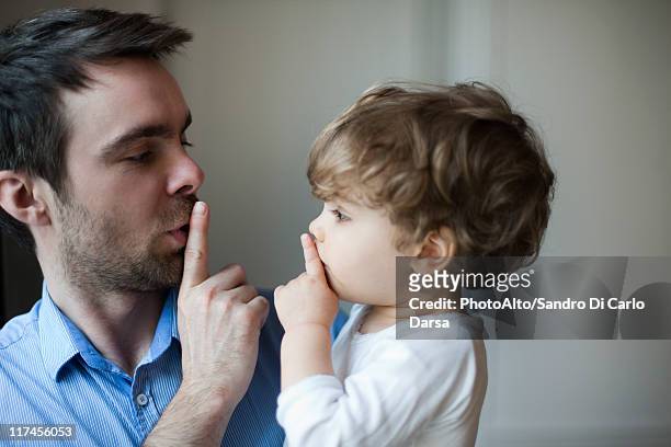 father teaching toddler son to hush - erwachsene imitieren stock-fotos und bilder