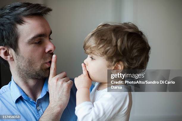 father teaching toddler son to hush - silêncio - fotografias e filmes do acervo