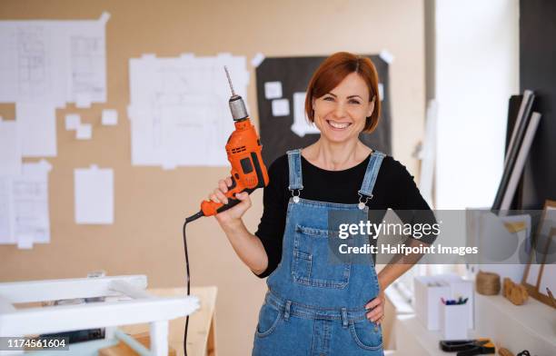 woman vlogger or blogger with electric drill making video about old furniture restoration. - drill stock pictures, royalty-free photos & images