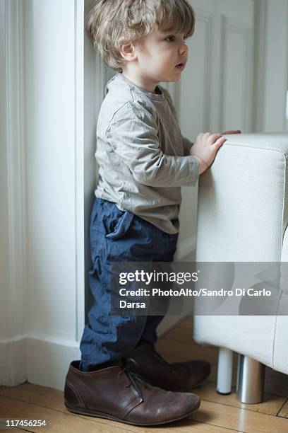 toddler boy in father's shoes, portrait - loose stock-fotos und bilder