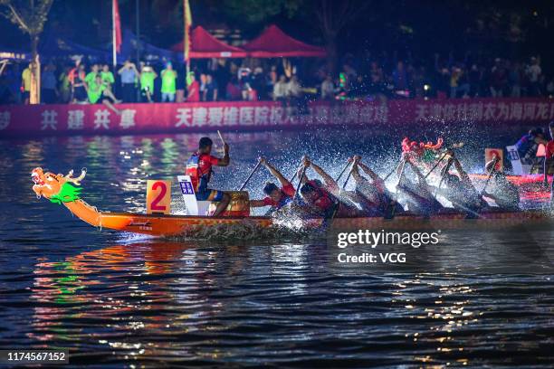 Competitors take part in a dragon boat race on Haihe River to celebrate the Mid-Autumn Festival on September 13, 2019 in Tianjin, China. 2019...