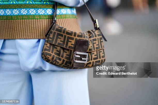 Guest wears a Fendi logo monogram bag, during London Fashion Week September 2019 on September 13, 2019 in London, England.