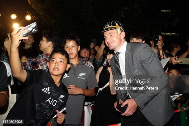 Beauden Barrett of the All Blacks signs autographs for fans during a New Zealand All Blacks Rugby World Cup Welcome Ceremony at Zojoji Temple on...