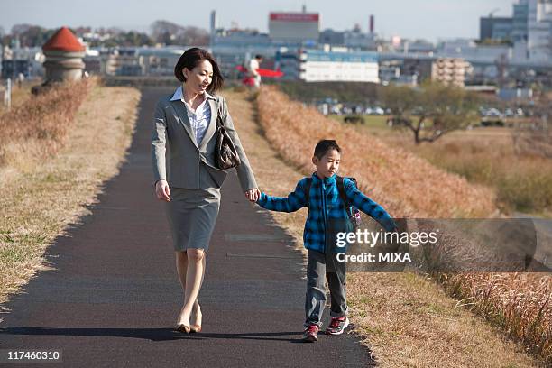 working mother and son walking together - embankment stock pictures, royalty-free photos & images