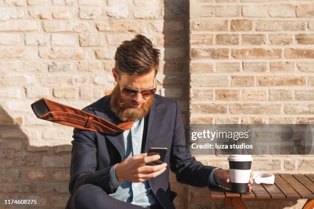 a swedish man is using his smart phone on a coffee break in the city - windy city stock pictures, royalty-free photos & images