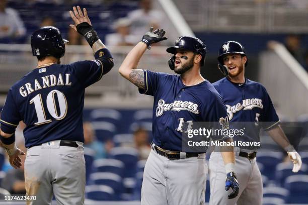 Mike Moustakas of the Milwaukee Brewers celebrates with Yasmani Grandal and Cory Spangenberg after hitting a three-run home run in the third inning...