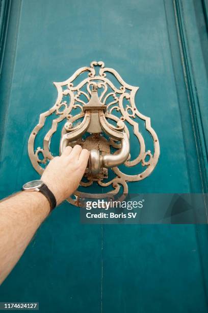man knocking at the door with steel doorknob, bordeaux, france - knocking photos et images de collection