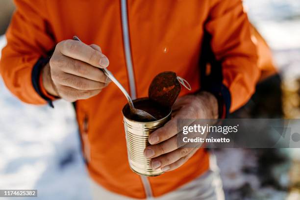 tourist hiker eating canned food near tent - all you can eat stock pictures, royalty-free photos & images