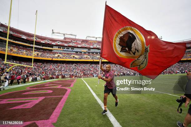 Washington Redskins cheerleader on field with flag with team logo before game vs New England Patriots at FedEx Field. Landover, MD 10/6/2019 CREDIT:...