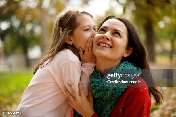 moeder en dochter spelen in het park - child whispering stockfoto's en -beelden
