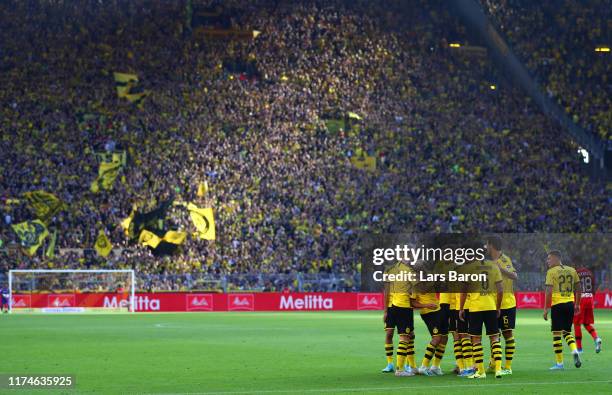 Raphael Guerreiro of Borussia Dortmund celebrates after scoring his team's third goal with team mates during the Bundesliga match between Borussia...