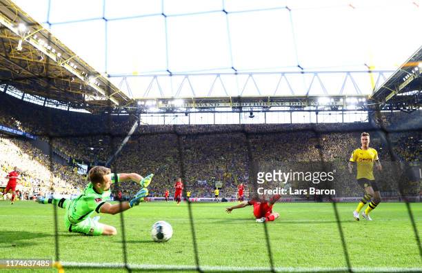 Marco Reus of Borussia Dortmund scores his team's fourth goal past Lukas Hradecky of Bayer 04 Leverkusen during the Bundesliga match between Borussia...