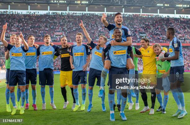 Rami Bensebaini and Marcus Thuram of Borussia Monchengladbach and team mates celebrate victory after the Bundesliga match between 1. FC Koeln and...