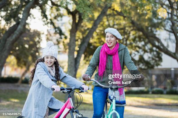 hispanic mother and daughter on bicycles - family sports centre laughing stock pictures, royalty-free photos & images