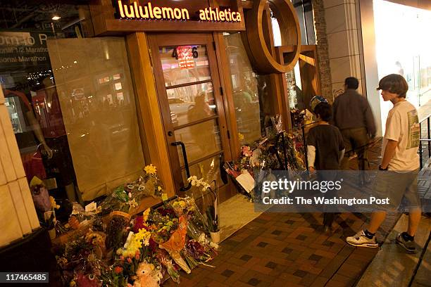 Bystander looks at the flowers left for Lululemon employee Jayna Murray who was killed allegedly by her co-worker. Friends and the community have a...