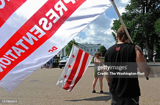 Meredith Begin and Adam Eidinger hold their flags on Pennsylvania Ave in front of The White House before the rally began on June 25, 2010. They were...