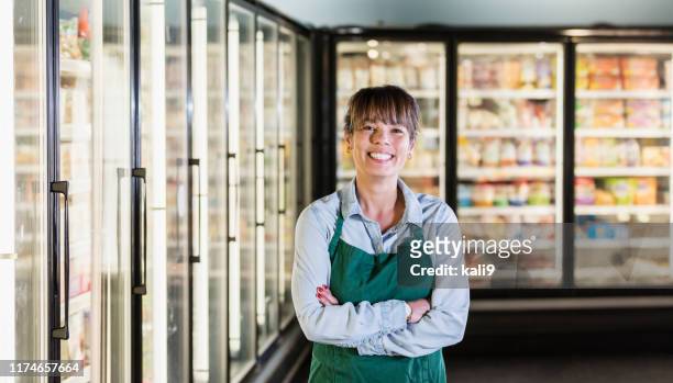 employee in refrigerated section of supermarket - frozen food stock pictures, royalty-free photos & images