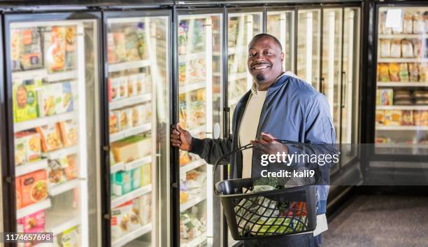 hombre afroamericano comprando comestibles - frozen food fotografías e imágenes de stock