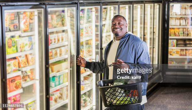 african-american man shopping for groceries - frozen food stock pictures, royalty-free photos & images