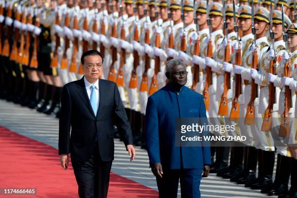 Solomon Islands Prime Minister Manasseh Sogavare and Chinese Premier Li Keqiang inspect honour guards during a welcome ceremony at the Great Hall of...