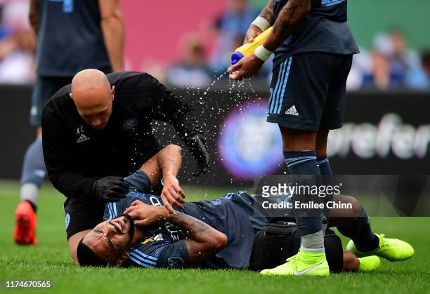 Alexander Callens of New York City FC lays on the ground with a trainer during their game against San Jose at Yankee Stadium on September 14, 2019 in...