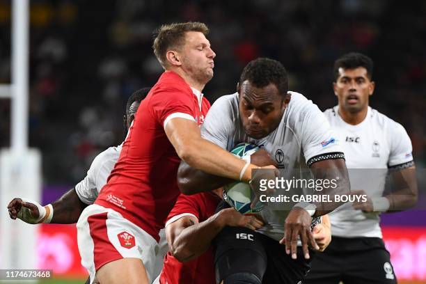 Wales' fly-half Dan Biggar tackles Fiji's lock Leone Nakarawa during the Japan 2019 Rugby World Cup Pool D match between Wales and Fiji at the Oita...