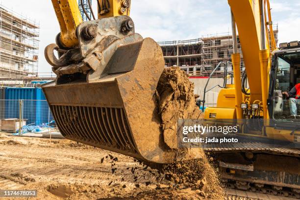 industrial earth mover scoops up a huge amount of sand - archeology foto e immagini stock