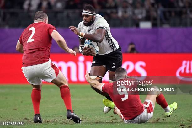 Fiji's flanker Semi Kunatani runs a he is tackled by Wales' hooker Ken Owens and Wales' scrum-half Gareth Davies during the Japan 2019 Rugby World...