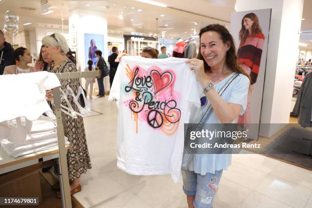 Guests shows up an airbrush painted t-shirt at the Esprit booth during a special day on September 14, 2019 in Frankfurt am Main, Germany.