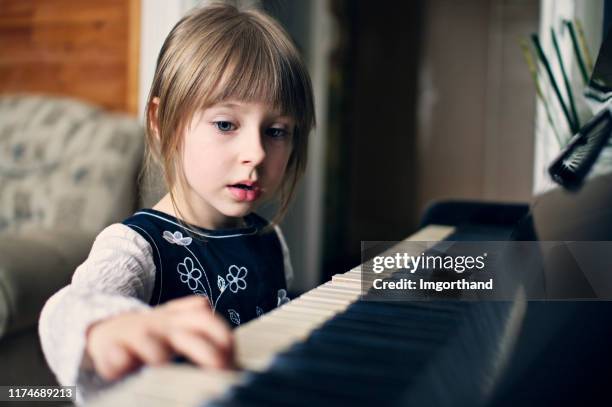 four years old girl playing piano and singing - pianist portrait stock pictures, royalty-free photos & images