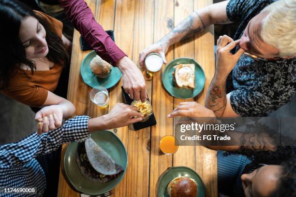 top view of friends having a lunch together - friendship over stock pictures, royalty-free photos & images