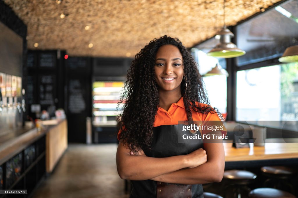Retrato da empregada de mesa/proprietário africanos da etnia no restaurante