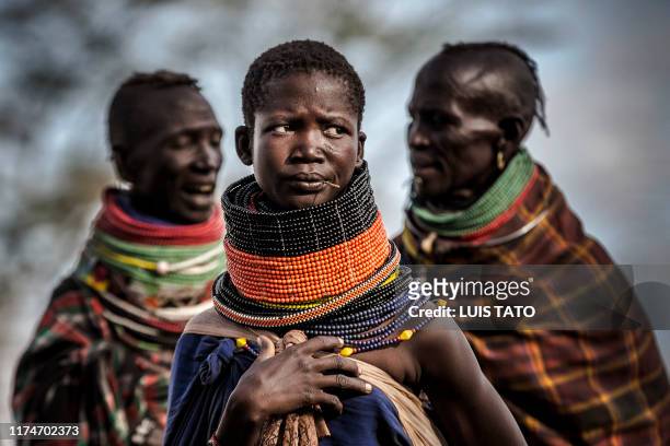 Women belonging to the Turkana community gather next to their village in an arid dry area in Morungole, Turkana County, Kenya, on October 7, 2019. -...