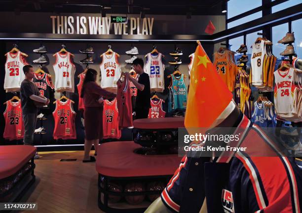 Chinese flag is seen placed on a mannequin wearing the USA basketball uniform as Chinese shoppers look at clothing in the NBA flagship retail store...