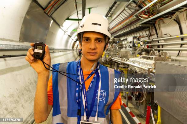 Scientist and guide shows the time visitors have been in the tunnel during the Open Days at the CERN particle physics research facility on September...