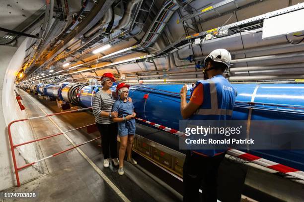 Guide and scientist takes a picture to visitorsat the tunnels at Point 4 section during the Open Days at the CERN particle physics research facility...