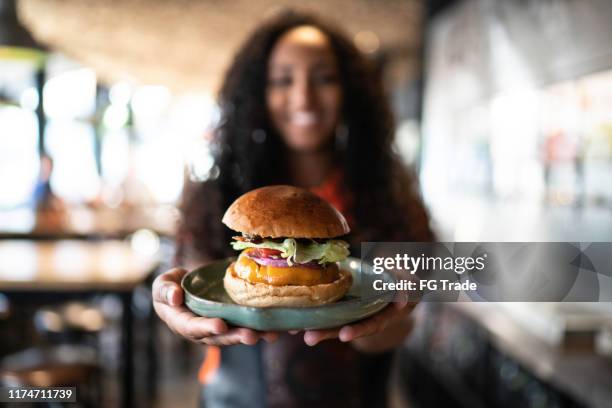 waitress holding / showing a sandwich - utensílio de servir imagens e fotografias de stock