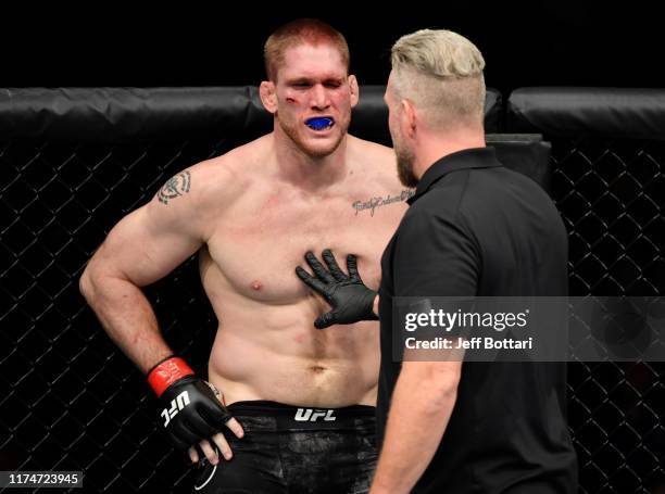 Todd Duffee reacts after suffering an eye-poke from Jeff Hughes in their heavyweight bout during the UFC Fight Night event at Rogers Arena on...