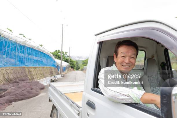 japanischer senior mann fährt klein-lkw - old truck stock-fotos und bilder