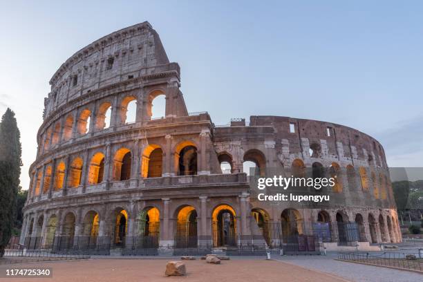 coliseum in rome at dusk - colosseum stock pictures, royalty-free photos & images