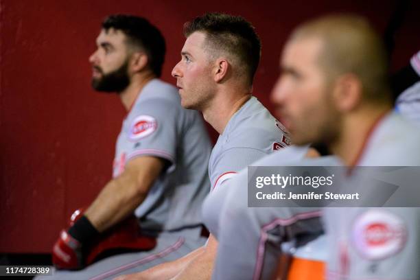 Anthony DeSclafani of the Cincinnati Reds sits in between Jose Peraza and Joey Votto during the MLB game against the Arizona Diamondbacks at Chase...