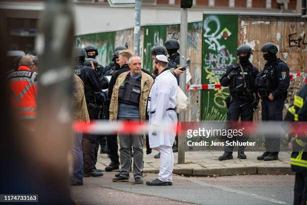 Rescued parishioners of the Jewish community and police forces stand near the scene of a shooting that has left two people dead on October 9, 2019 in...