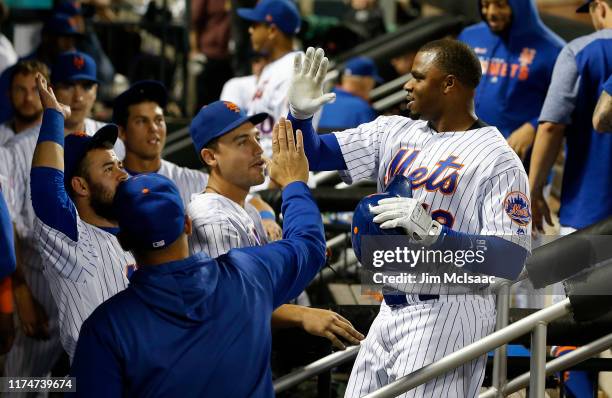 Rajai Davis of the New York Mets is congratulated by his teammates in the dugout after the eighth inning against the Los Angeles Dodgers at Citi...